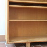 Enfilade scandinave vintage en chêne clair, porte coulissante à poignée gorge, étagères ouvertes à hauteur modulable, petits pieds ronds, faible profondeur 33 cm