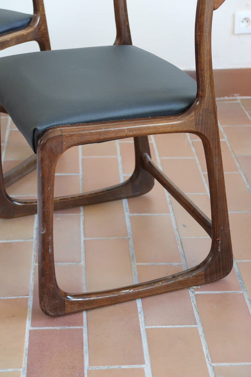 Suite de 3 chaises traîneau Baumann vintage en hêtre teinté foncé années 60, piétement luge, assises skaï noir refaites