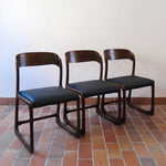 Suite de 3 chaises traîneau Baumann vintage en hêtre teinté foncé années 60, piétement luge, assises skaï noir refaites