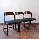 Suite de 3 chaises traîneau Baumann vintage en hêtre teinté foncé années 60, piétement luge, assises skaï noir refaites