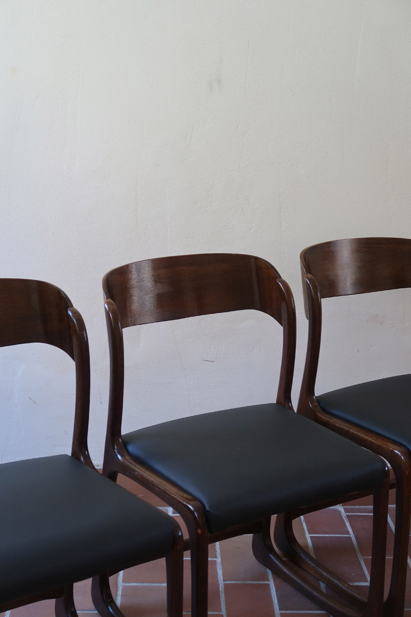 Suite de 3 chaises traîneau Baumann vintage en hêtre teinté foncé années 60, piétement luge, assises skaï noir refaites