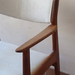 Fauteuil à accoudoirs scandinave vintage en teck années 60, dossier galbé, assise retapissée tissu écru