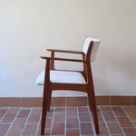 Fauteuil à accoudoirs scandinave vintage en teck années 60, dossier galbé, assise retapissée tissu écru
