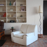 Fauteuil vintage Cinna en cuir crème années 70, étiquette d'origine cousue dans le dossier, accoudoirs et dossier en gros boudins de cuir, coussin d'assise, base pleine posée au sol sans pieds apparents