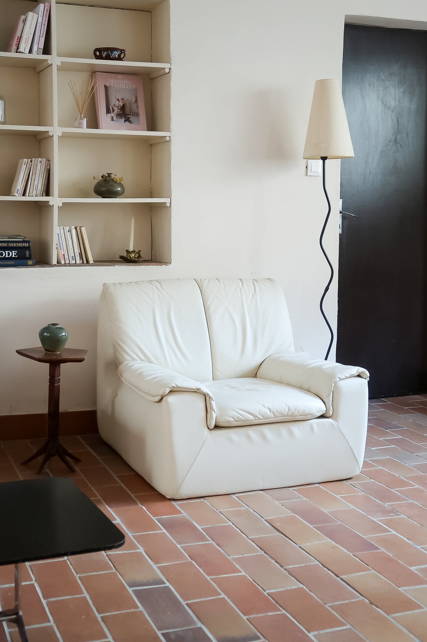 Fauteuil vintage Cinna en cuir crème années 70, étiquette d'origine cousue dans le dossier, accoudoirs et dossier en gros boudins de cuir, coussin d'assise, base pleine posée au sol sans pieds apparents