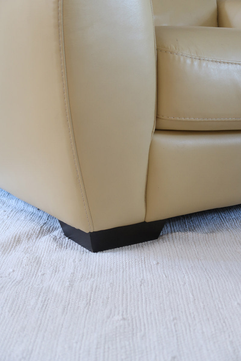 Fauteuil club vintage en cuir beige des années 80 avec accoudoirs larges et assise enveloppante.