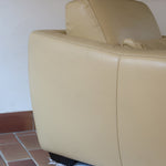 Fauteuil club vintage en cuir beige des années 80 avec accoudoirs larges et assise enveloppante.