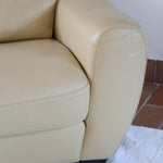 Fauteuil club vintage en cuir beige des années 80 avec accoudoirs larges et assise enveloppante.