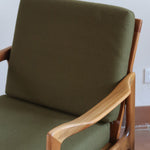 Fauteuil danois vintage en bois sculpté avec assise vert olive, design organique des années 60.
