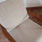 Fauteuil lounge scandinave vintage en teck années 60, accoudoirs effilés, dossier inclinable, coussins tissu chiné écru, esprit Komfort