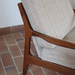 Fauteuil lounge scandinave vintage en teck années 60, accoudoirs effilés, dossier inclinable, coussins tissu chiné écru, esprit Komfort