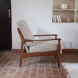 Fauteuil lounge scandinave vintage en teck années 60, accoudoirs effilés, dossier inclinable, coussins tissu chiné écru, esprit Komfort