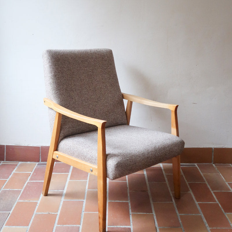 Fauteuil scandinave années 60 en bois clair avec assise retapissée tissu brun, accoudoirs galbés.