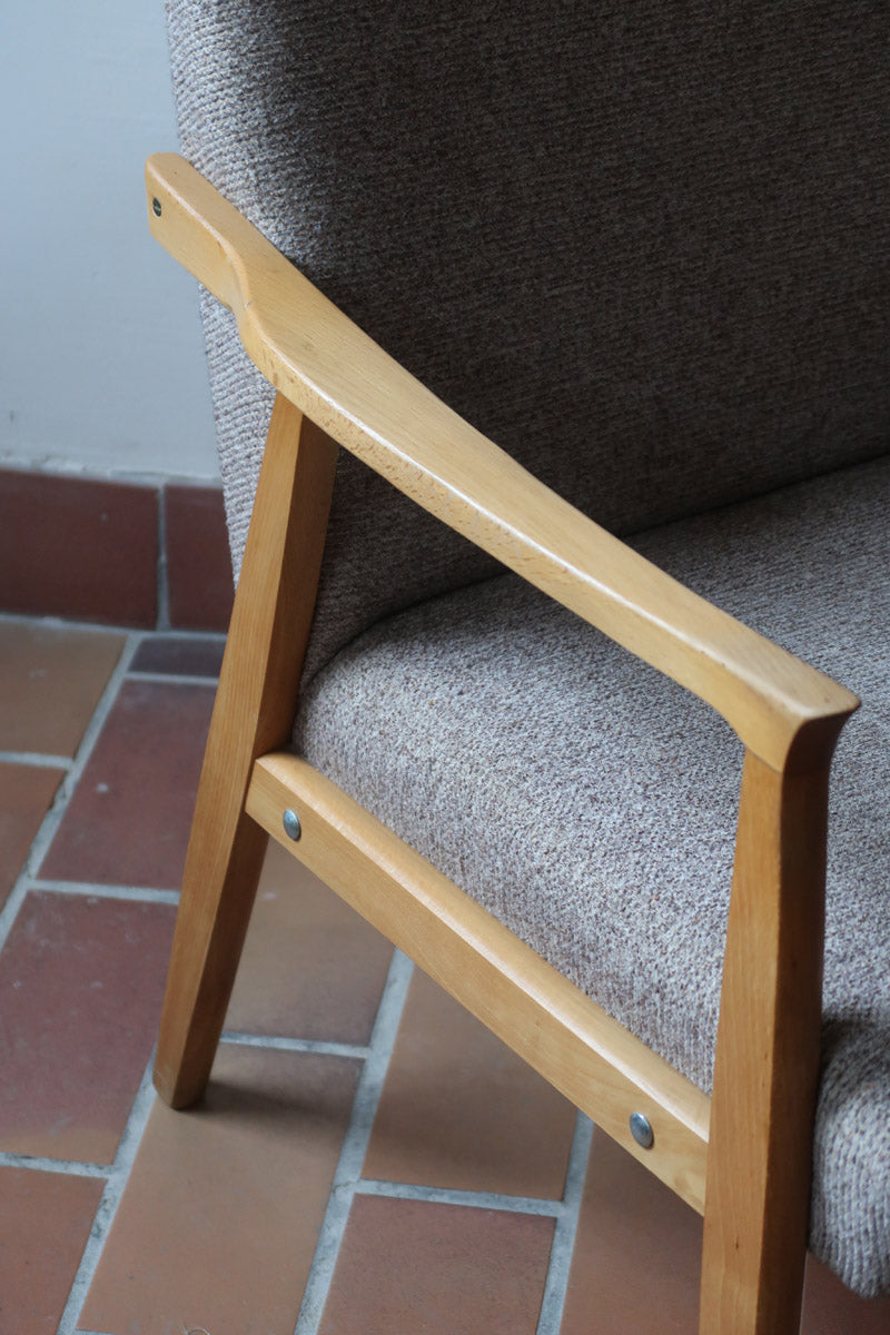 Fauteuil scandinave années 60 en bois clair avec assise retapissée tissu brun, accoudoirs galbés.