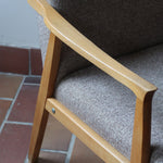 Fauteuil scandinave années 60 en bois clair avec assise retapissée tissu brun, accoudoirs galbés.