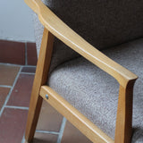 Fauteuil scandinave années 60 en bois clair avec assise retapissée tissu brun, accoudoirs galbés.