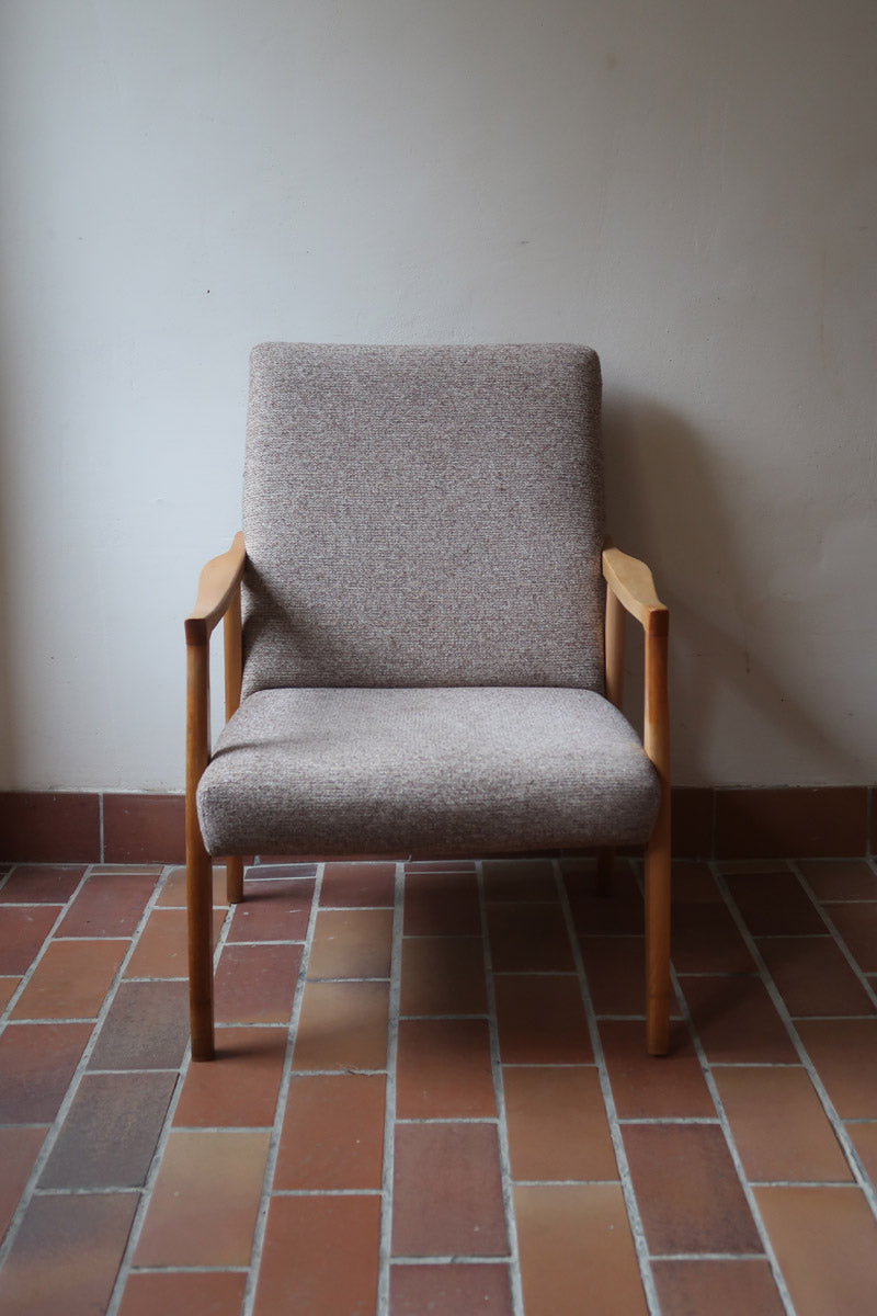 Fauteuil scandinave années 60 en bois clair avec assise retapissée tissu brun, accoudoirs galbés.