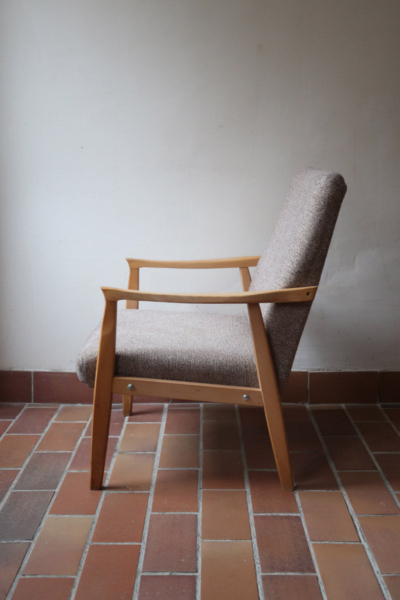 Fauteuil scandinave années 60 en bois clair avec assise retapissée tissu brun, accoudoirs galbés.
