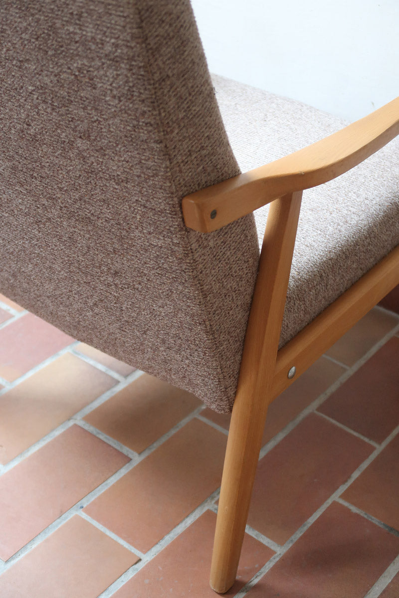 Fauteuil scandinave années 60 en bois clair avec assise retapissée tissu brun, accoudoirs galbés.