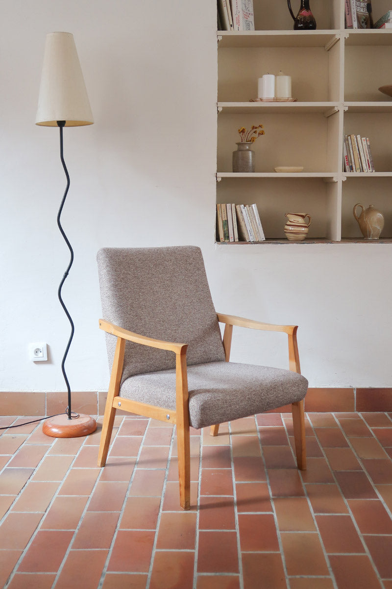 Fauteuil scandinave années 60 en bois clair avec assise retapissée tissu brun, accoudoirs galbés.