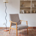 Fauteuil scandinave années 60 en bois clair avec assise retapissée tissu brun, accoudoirs galbés.