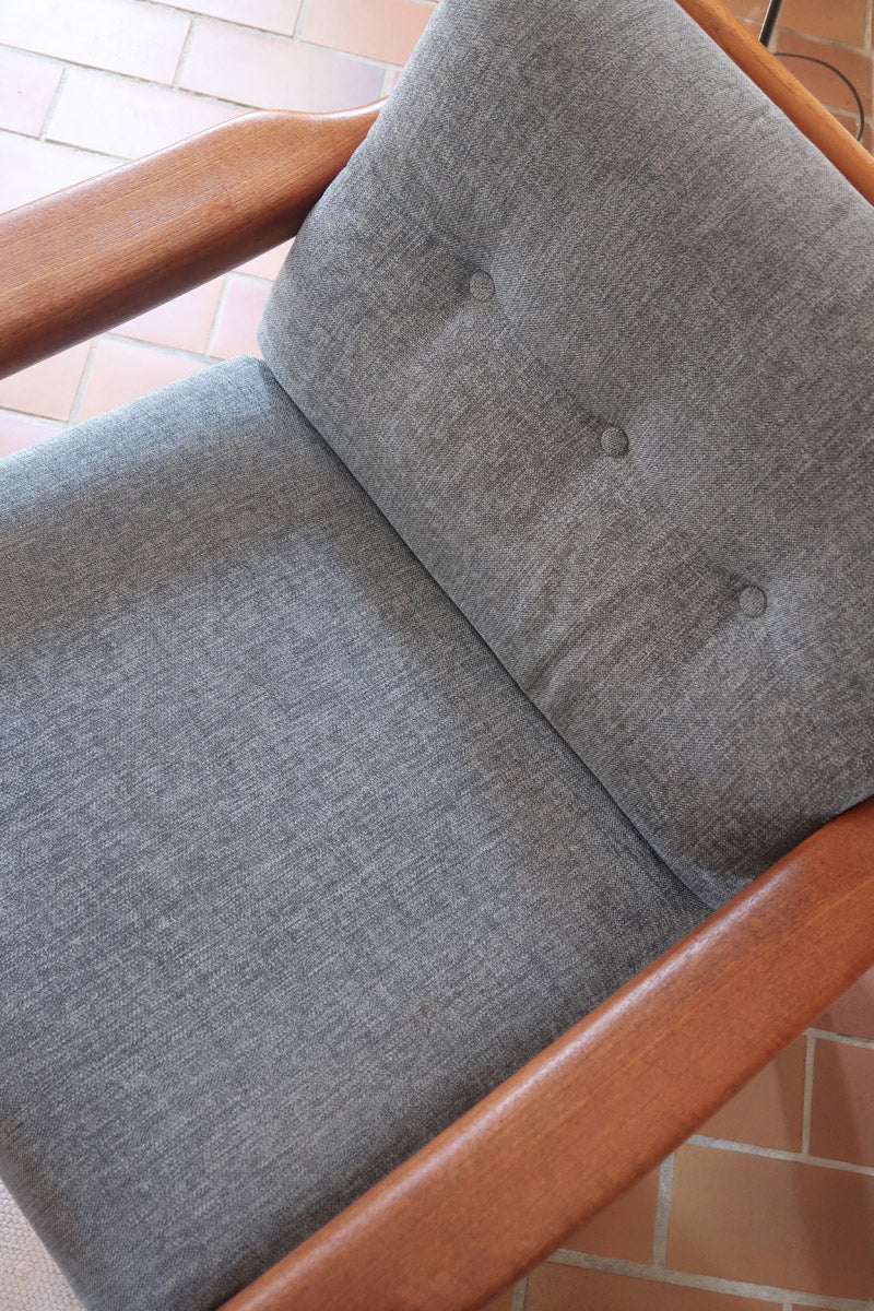 Fauteuil scandinave en teck Komfor avec coussins bleu gris déhoussables et piètement luge, fabriqué au Danemark.