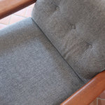 Fauteuil scandinave en teck Komfor avec coussins bleu gris déhoussables et piètement luge, fabriqué au Danemark.