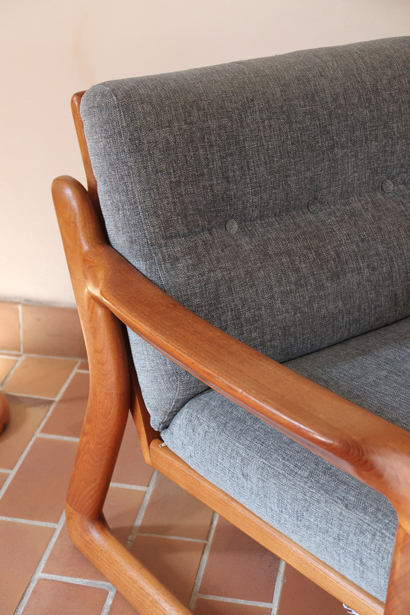 Fauteuil scandinave en teck Komfor avec coussins bleu gris déhoussables et piètement luge, fabriqué au Danemark.
