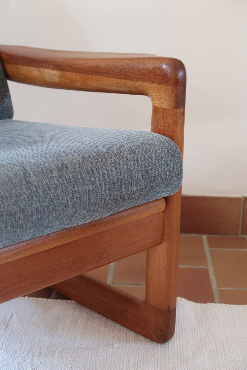 Fauteuil scandinave en teck Komfor avec coussins bleu gris déhoussables et piètement luge, fabriqué au Danemark.