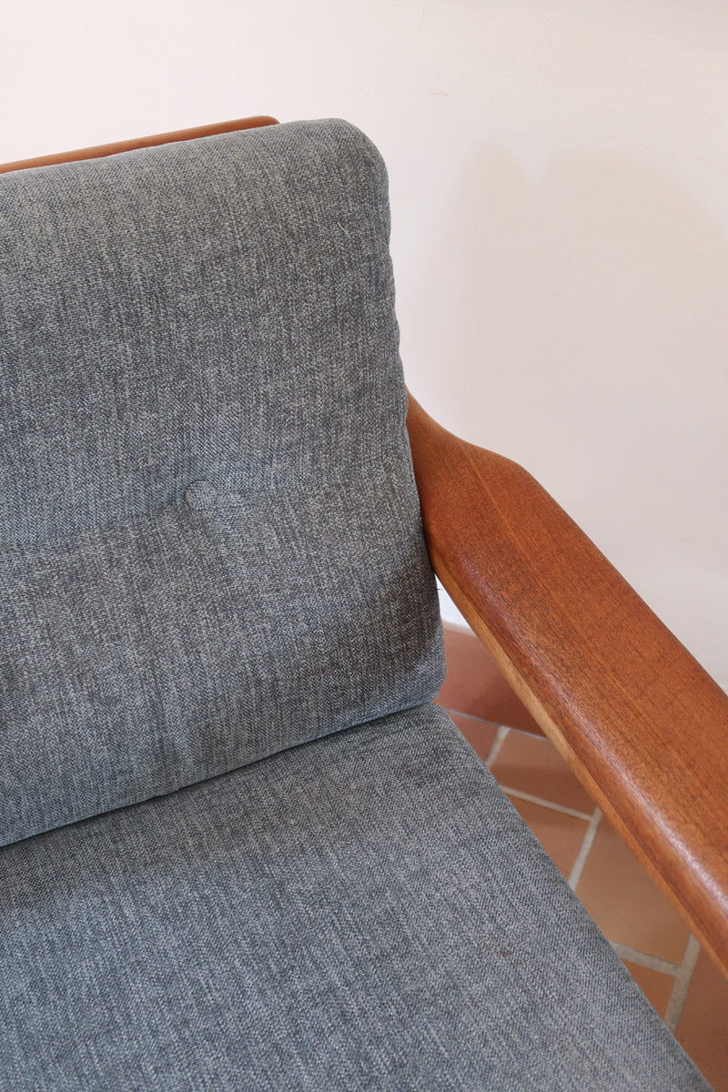 Fauteuil scandinave en teck Komfor avec coussins bleu gris déhoussables et piètement luge, fabriqué au Danemark.