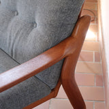 Fauteuil scandinave en teck Komfor avec coussins bleu gris déhoussables et piètement luge, fabriqué au Danemark.