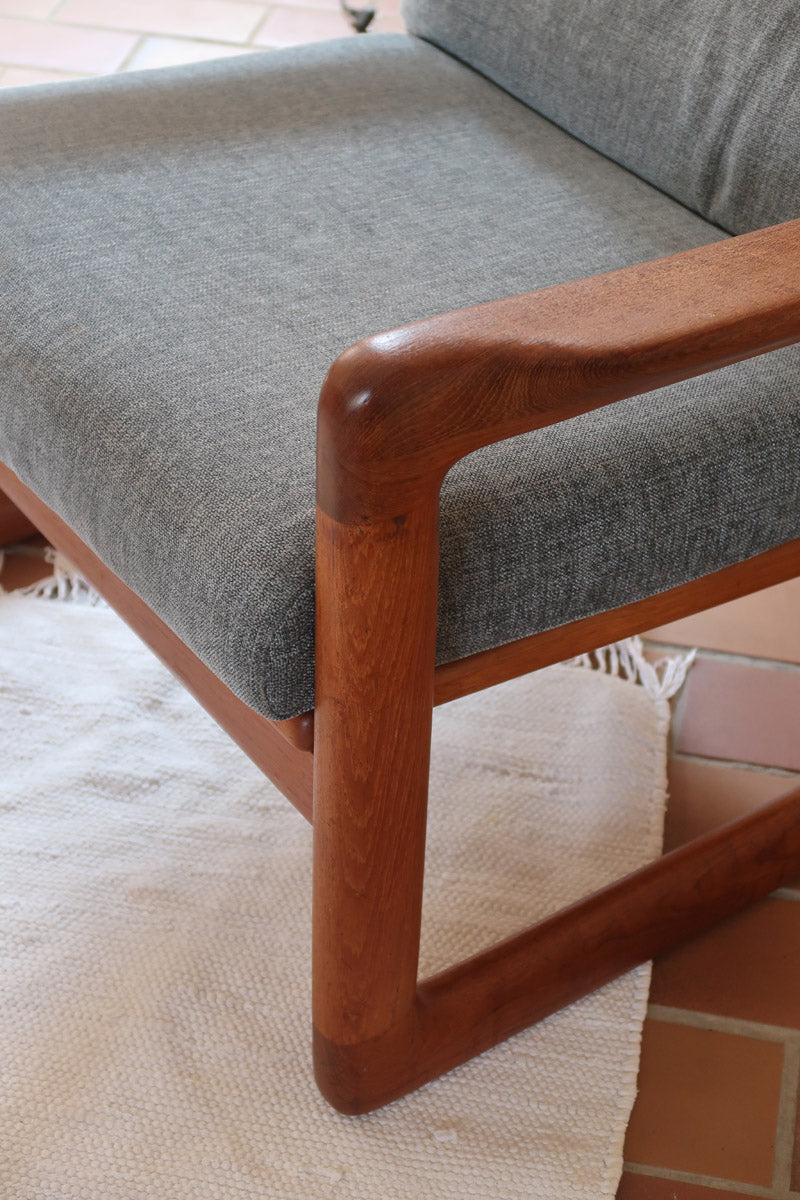 Fauteuil scandinave en teck Komfor avec coussins bleu gris déhoussables et piètement luge, fabriqué au Danemark.