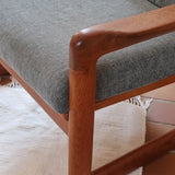Fauteuil scandinave en teck Komfor avec coussins bleu gris déhoussables et piètement luge, fabriqué au Danemark.