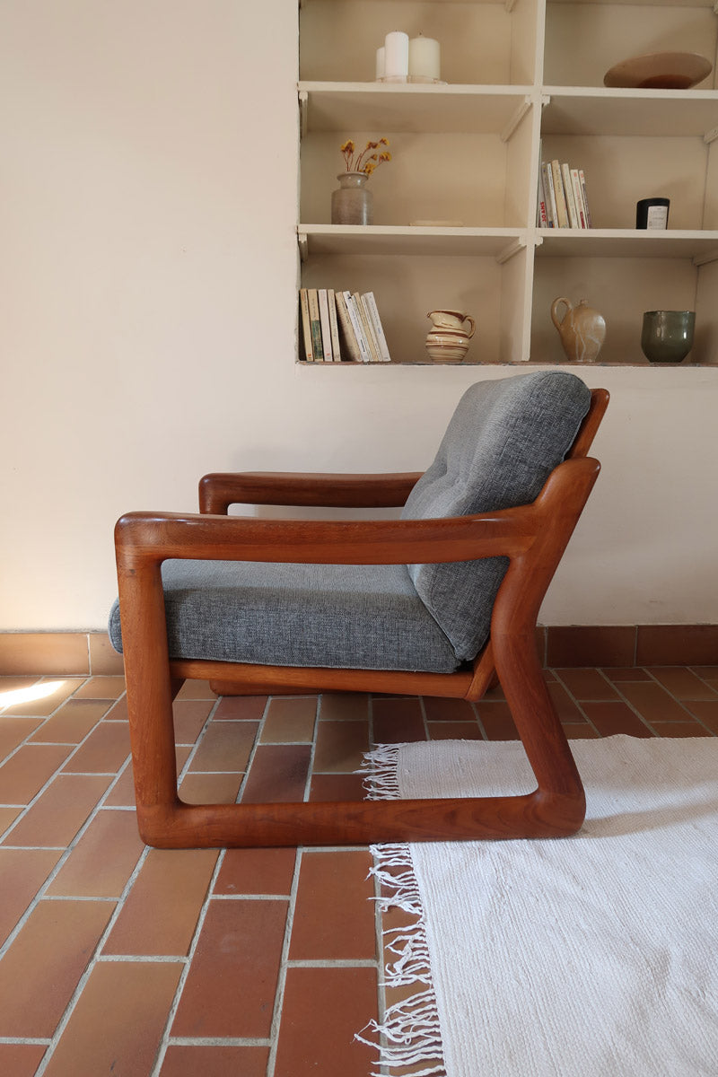Fauteuil scandinave en teck Komfor avec coussins bleu gris déhoussables et piètement luge, fabriqué au Danemark.