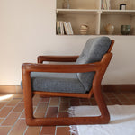 Fauteuil scandinave en teck Komfor avec coussins bleu gris déhoussables et piètement luge, fabriqué au Danemark.
