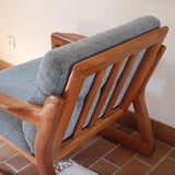 Fauteuil scandinave en teck Komfor avec coussins bleu gris déhoussables et piètement luge, fabriqué au Danemark.
