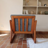Fauteuil scandinave en teck Komfor avec coussins bleu gris déhoussables et piètement luge, fabriqué au Danemark.