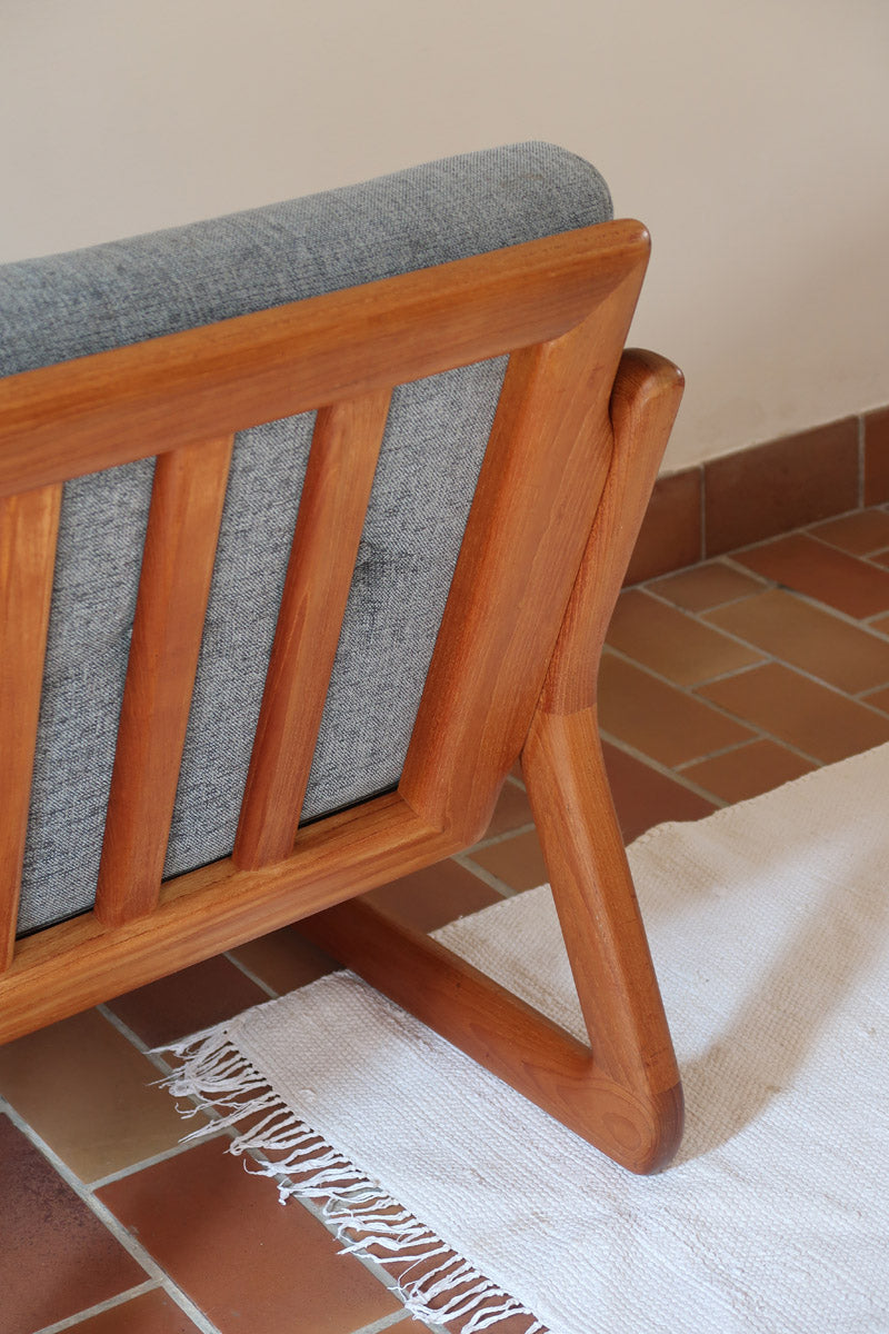 Fauteuil scandinave en teck Komfor avec coussins bleu gris déhoussables et piètement luge, fabriqué au Danemark.