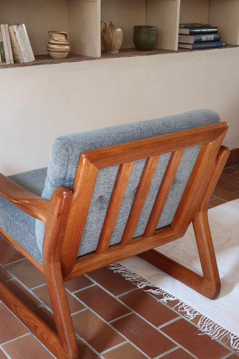 Fauteuil scandinave en teck Komfor avec coussins bleu gris déhoussables et piètement luge, fabriqué au Danemark.