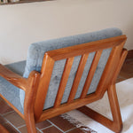 Fauteuil scandinave en teck Komfor avec coussins bleu gris déhoussables et piètement luge, fabriqué au Danemark.