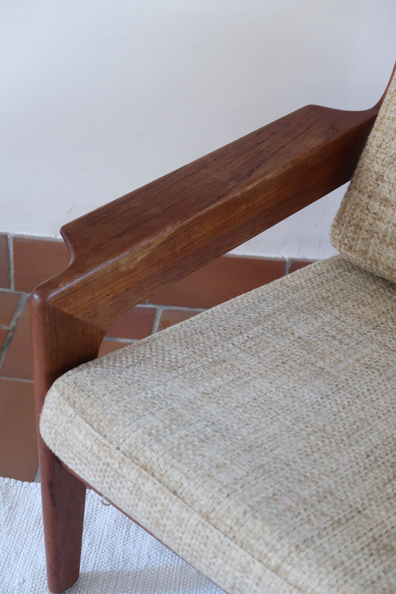 Fauteuil scandinave en teck des années 60 avec coussins beige et dossier à barreaux.
