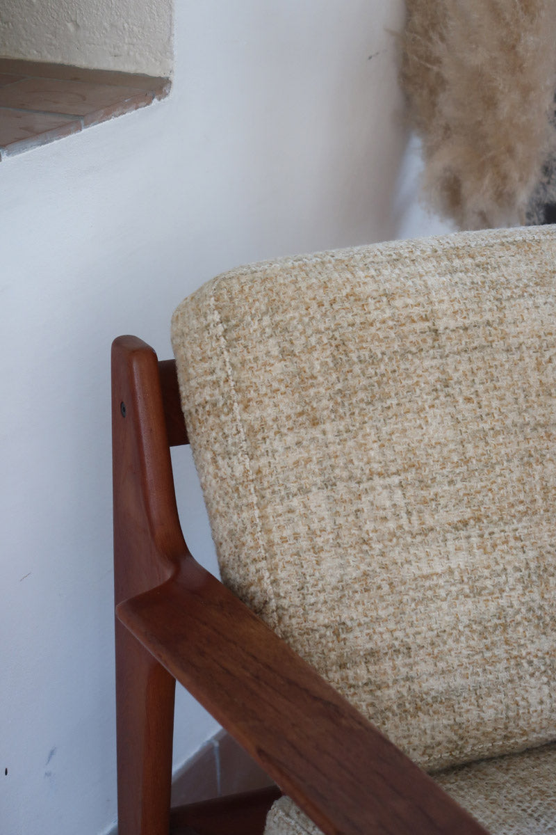 Fauteuil scandinave en teck des années 60 avec coussins beige et dossier à barreaux.