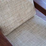 Fauteuil scandinave en teck des années 60 avec coussins beige et dossier à barreaux.