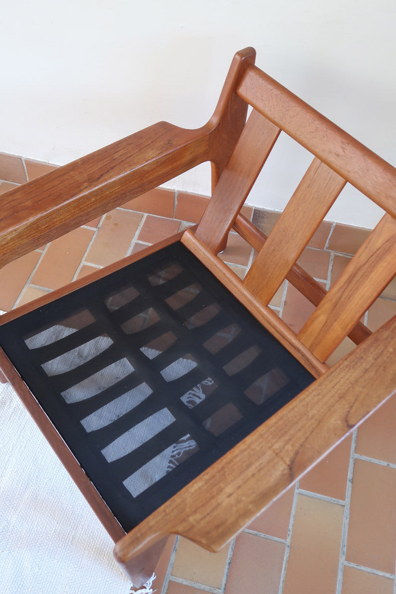 Fauteuil scandinave en teck des années 60 avec coussins beige et dossier à barreaux.