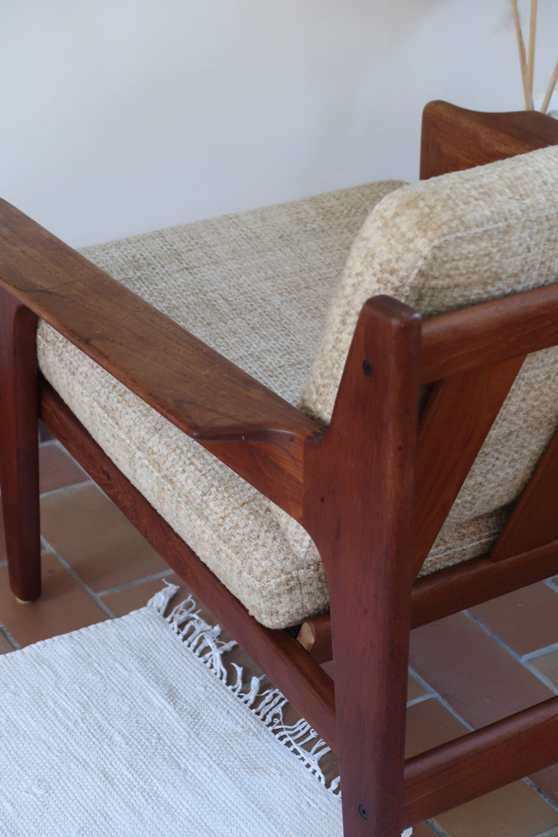 Fauteuil scandinave en teck des années 60 avec coussins beige et dossier à barreaux.