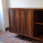 Grande enfilade vintage en palissandre de 240 cm, placage au fil en miroir, deux caissons fermant à clé de part et d'autre d'une niche centrale ouverte, tablettes intérieures en bois clair, reposant sur deux pieds pleins posés en retrait