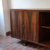 Grande enfilade vintage en palissandre de 240 cm, placage au fil en miroir, deux caissons fermant à clé de part et d'autre d'une niche centrale ouverte, tablettes intérieures en bois clair, reposant sur deux pieds pleins posés en retrait