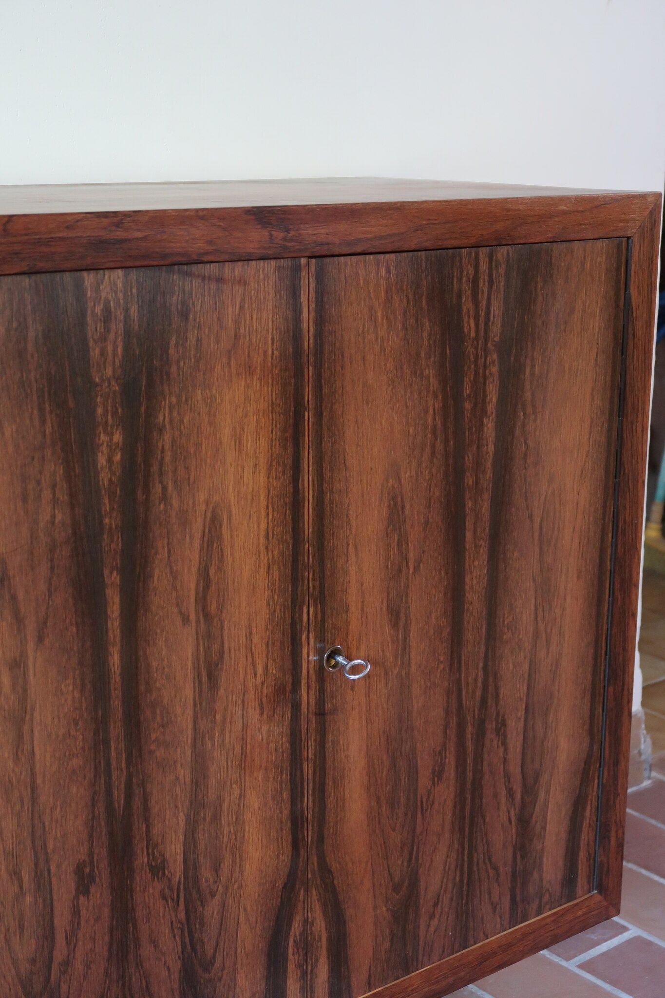 Grande enfilade vintage en palissandre de 240 cm, placage au fil en miroir, deux caissons fermant à clé de part et d'autre d'une niche centrale ouverte, tablettes intérieures en bois clair, reposant sur deux pieds pleins posés en retrait