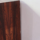 Grande enfilade vintage en palissandre de 240 cm, placage au fil en miroir, deux caissons fermant à clé de part et d'autre d'une niche centrale ouverte, tablettes intérieures en bois clair, reposant sur deux pieds pleins posés en retrait