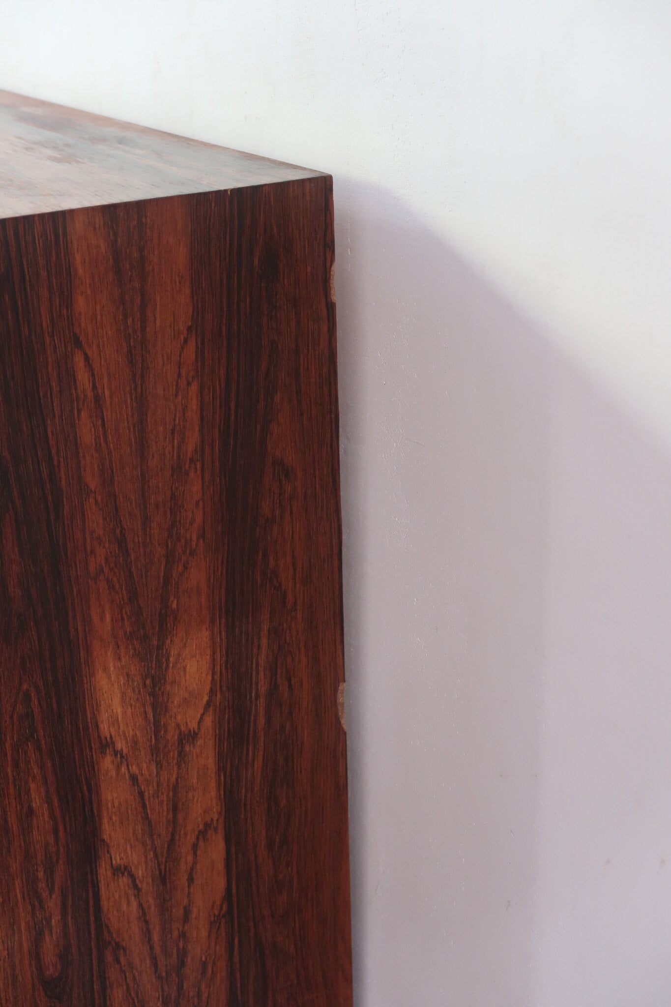 Grande enfilade vintage en palissandre de 240 cm, placage au fil en miroir, deux caissons fermant à clé de part et d'autre d'une niche centrale ouverte, tablettes intérieures en bois clair, reposant sur deux pieds pleins posés en retrait